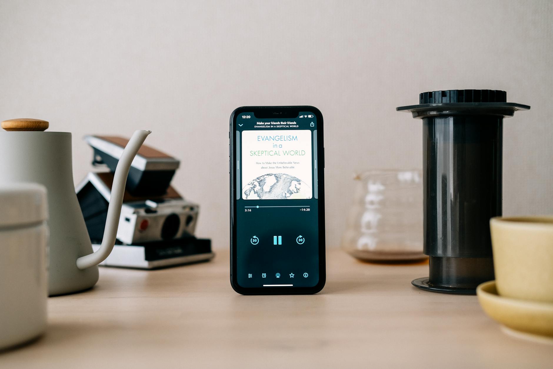 AeroPress coffee setup on a table with kettle pouring hot water