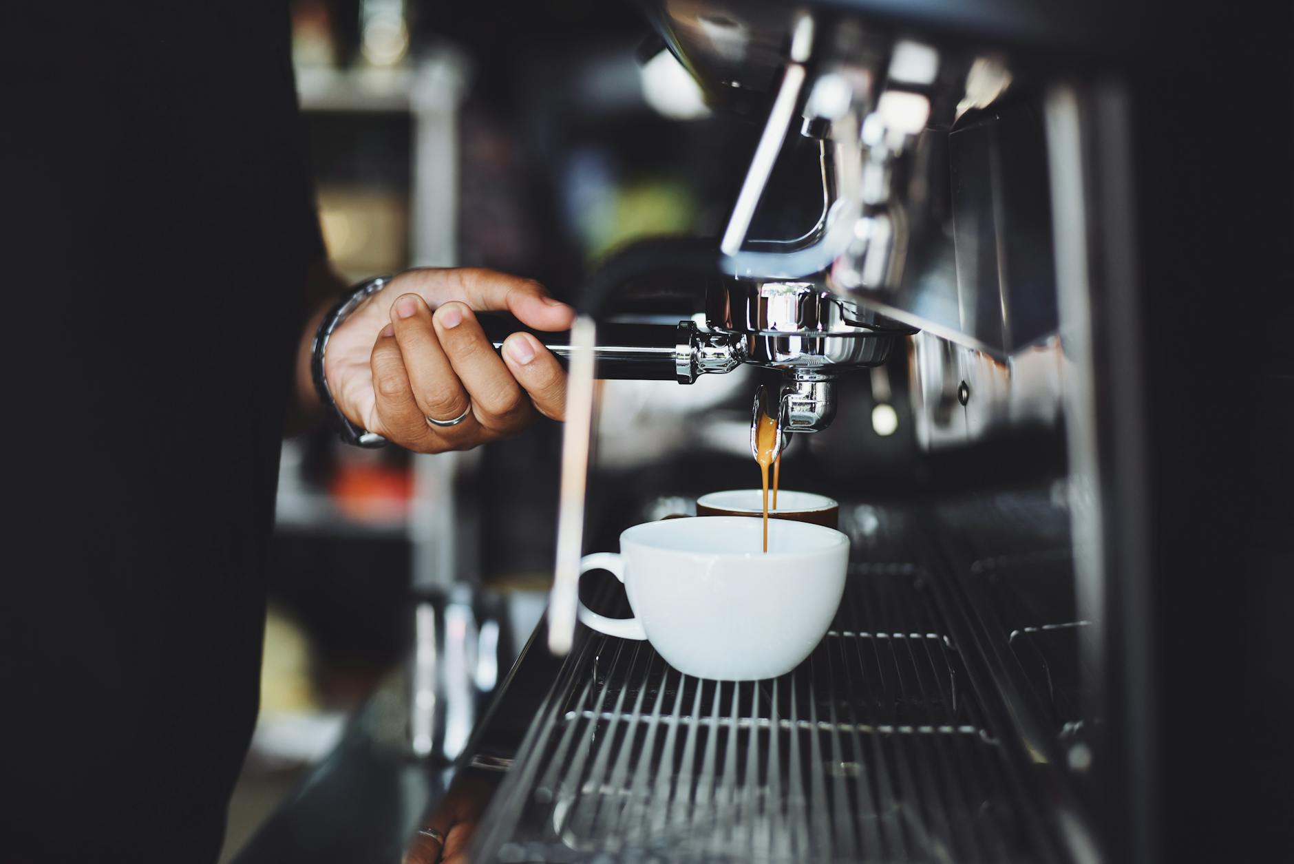 Close-up of an espresso machine pulling a shot of coffee