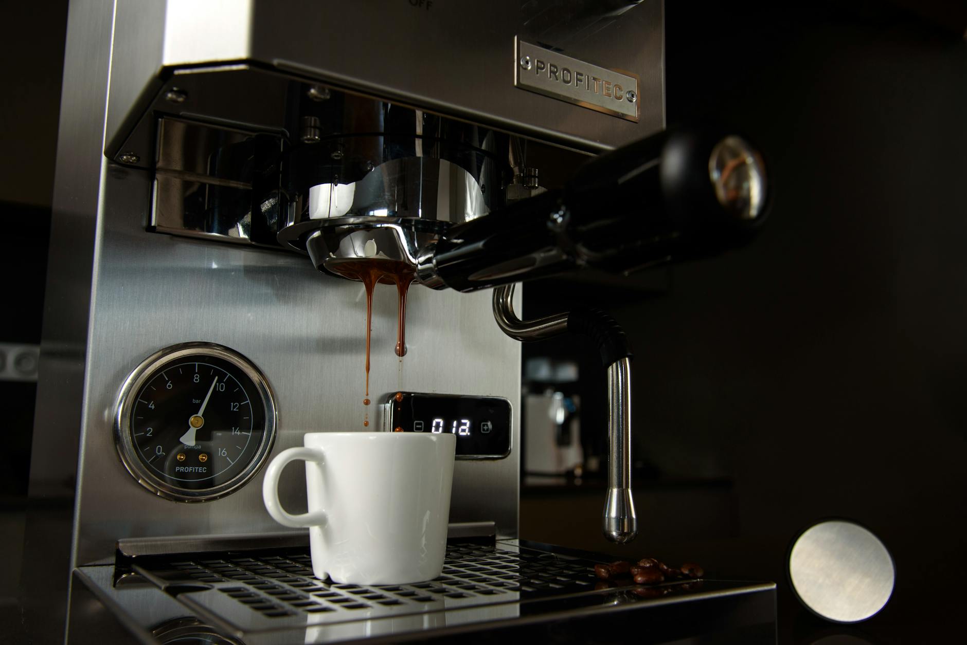 Close-up detail of espresso machine showing pressure gauge and steam controls
