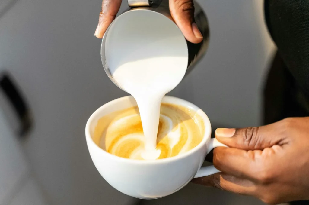 Barista pouring textured milk into espresso for a latte — best milk frothers UK