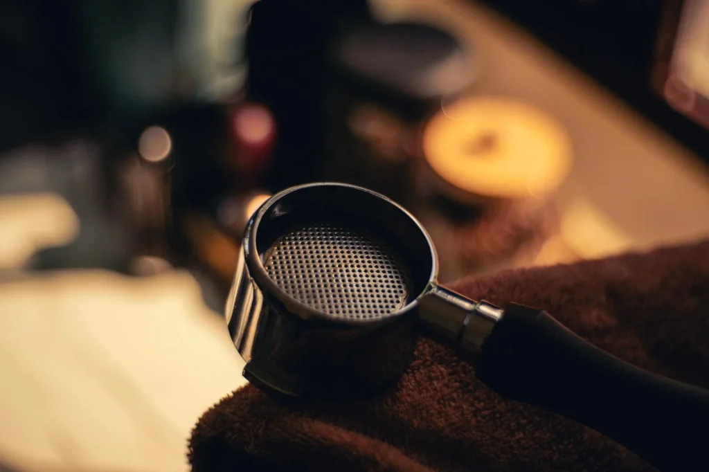 Close-up of an espresso machine group head with portafilter locked in