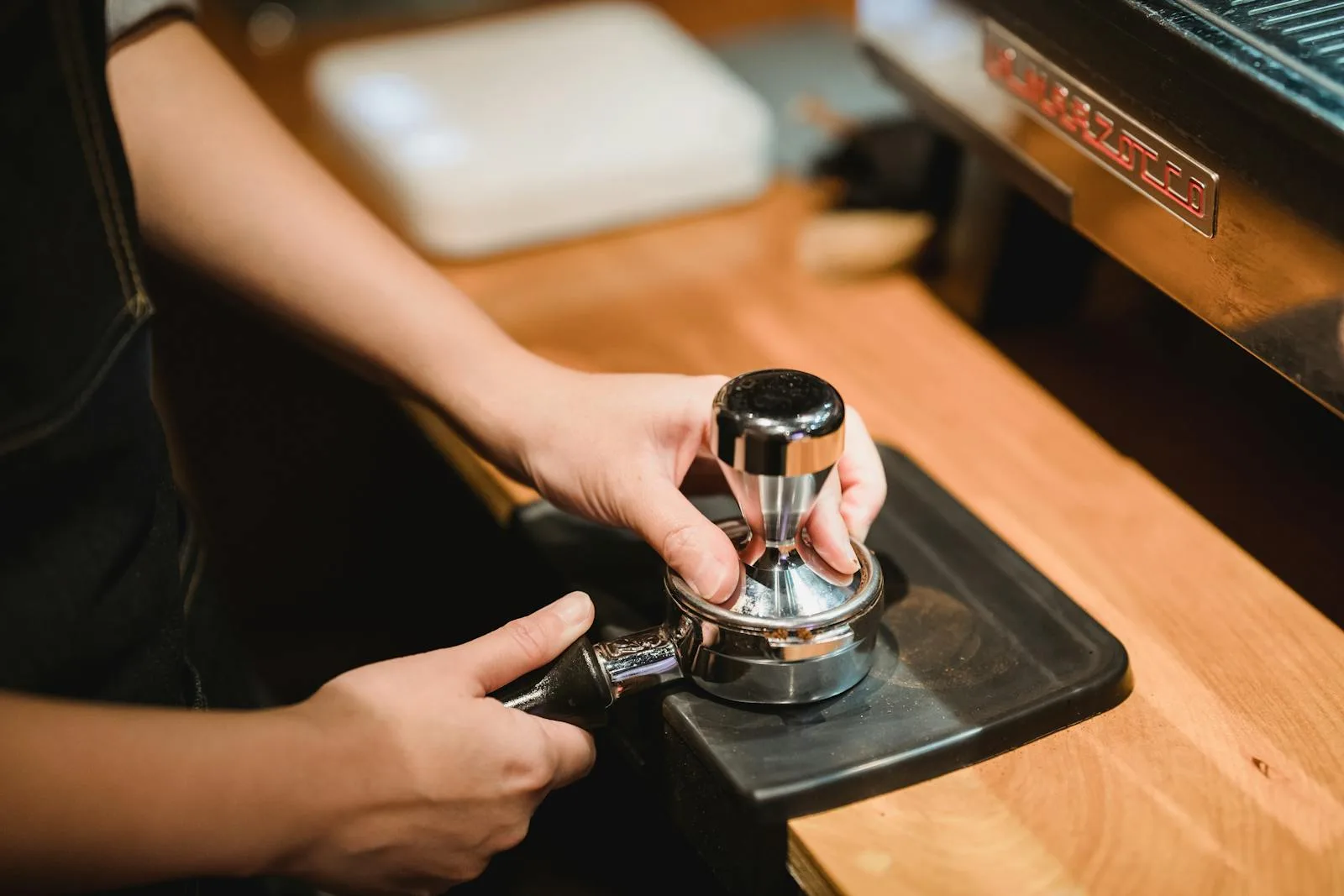 Espresso tamping station with machine in background for daily coffee workflow