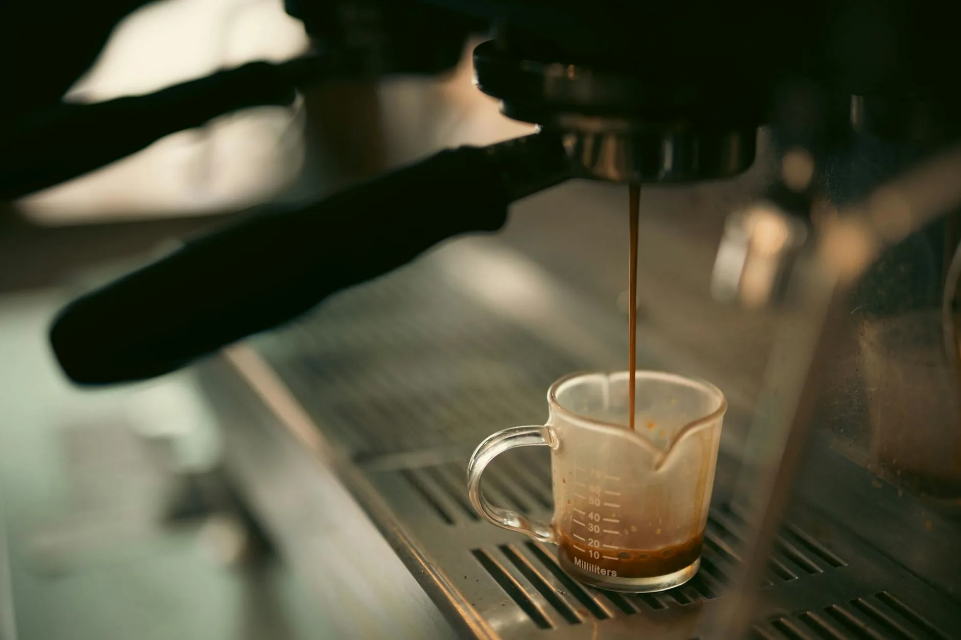 Espresso shot pouring into a cup with rich crema from a home espresso machine