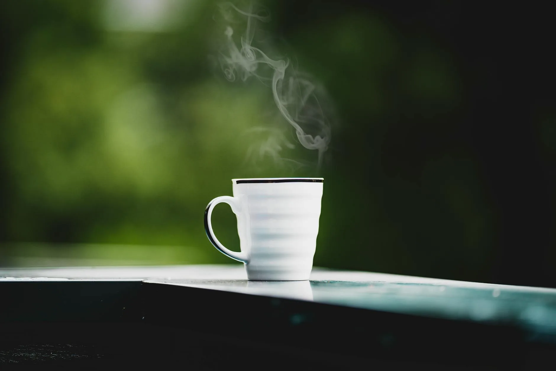 Fresh cup of coffee steaming on a morning table