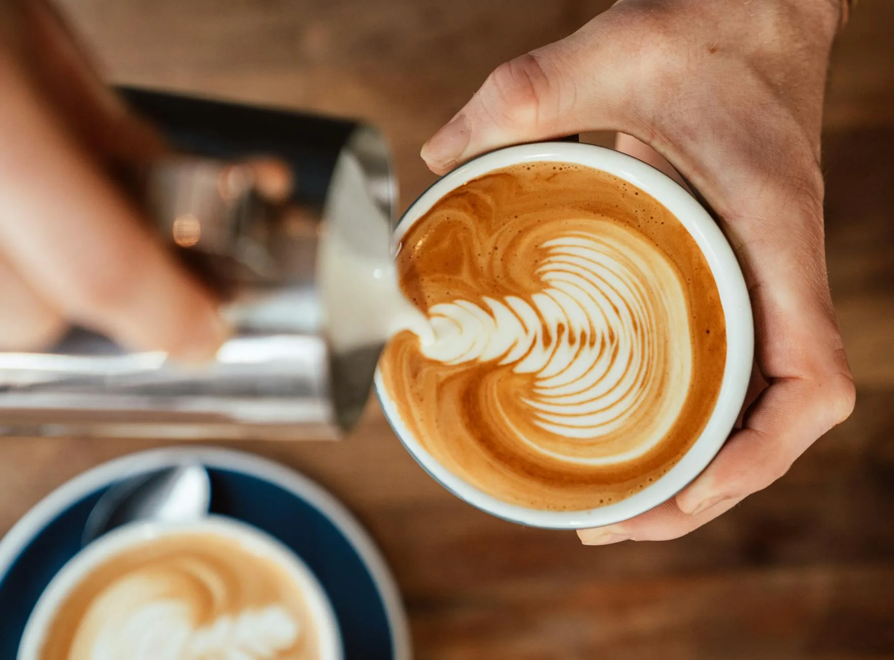 Latte art being poured into a coffee cup