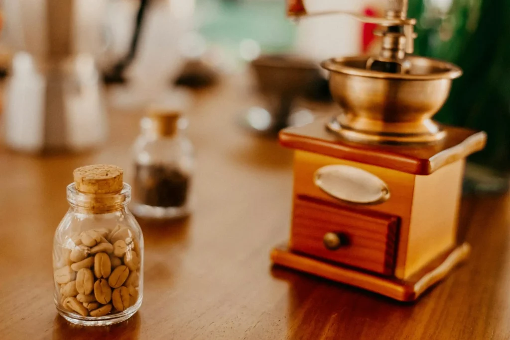 Coffee grinder with freshly ground beans on a wooden table