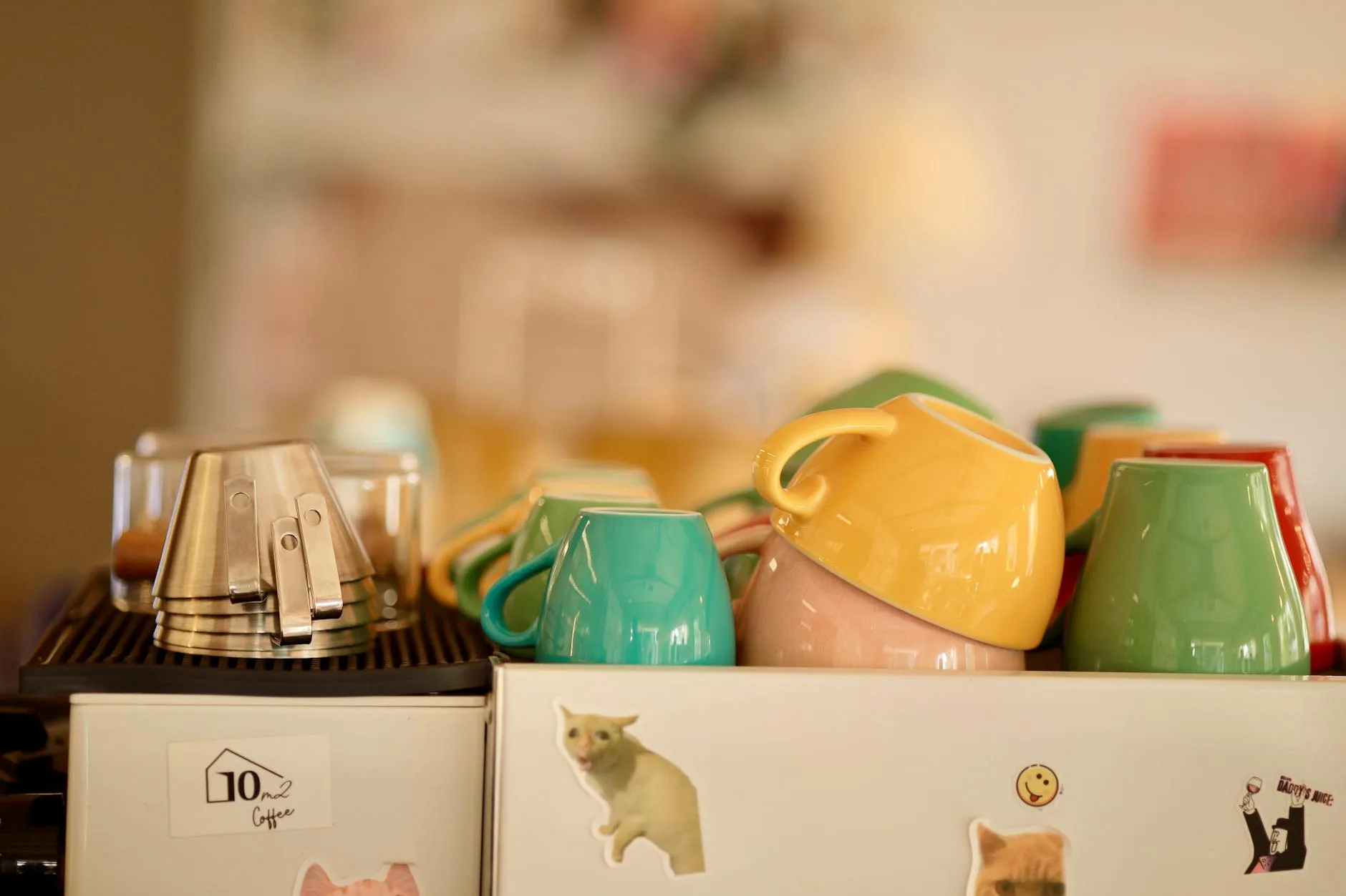 Collection of reusable coffee cups on a kitchen shelf