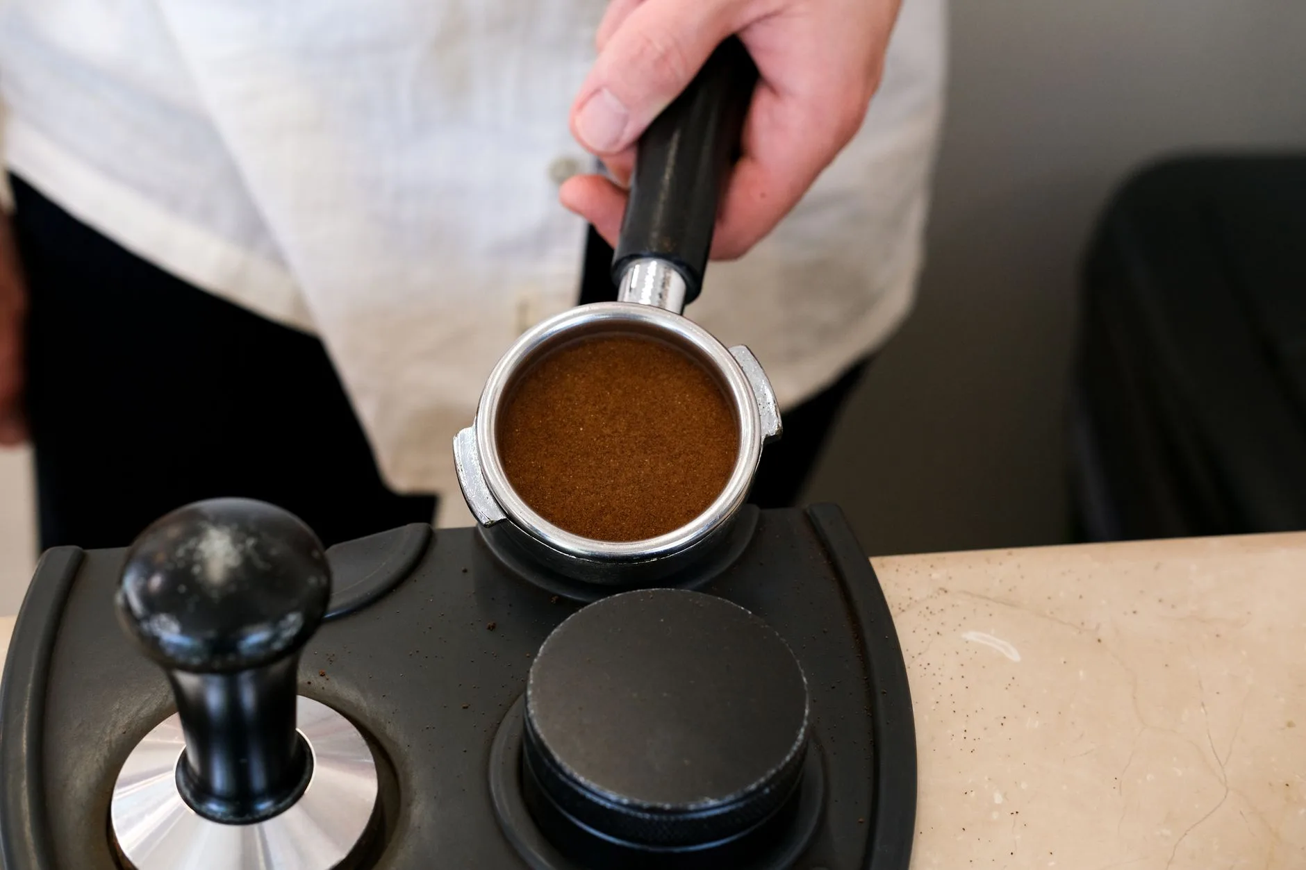 Tamping mat and espresso accessories set up on a coffee station counter