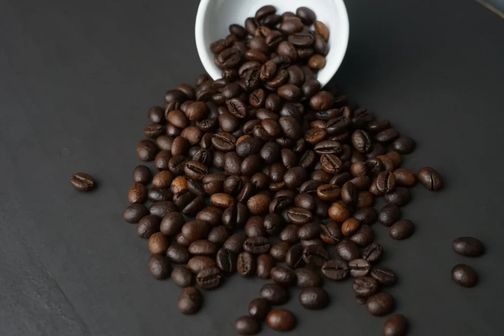 Decaf coffee beans beside a brewed cup in a kitchen