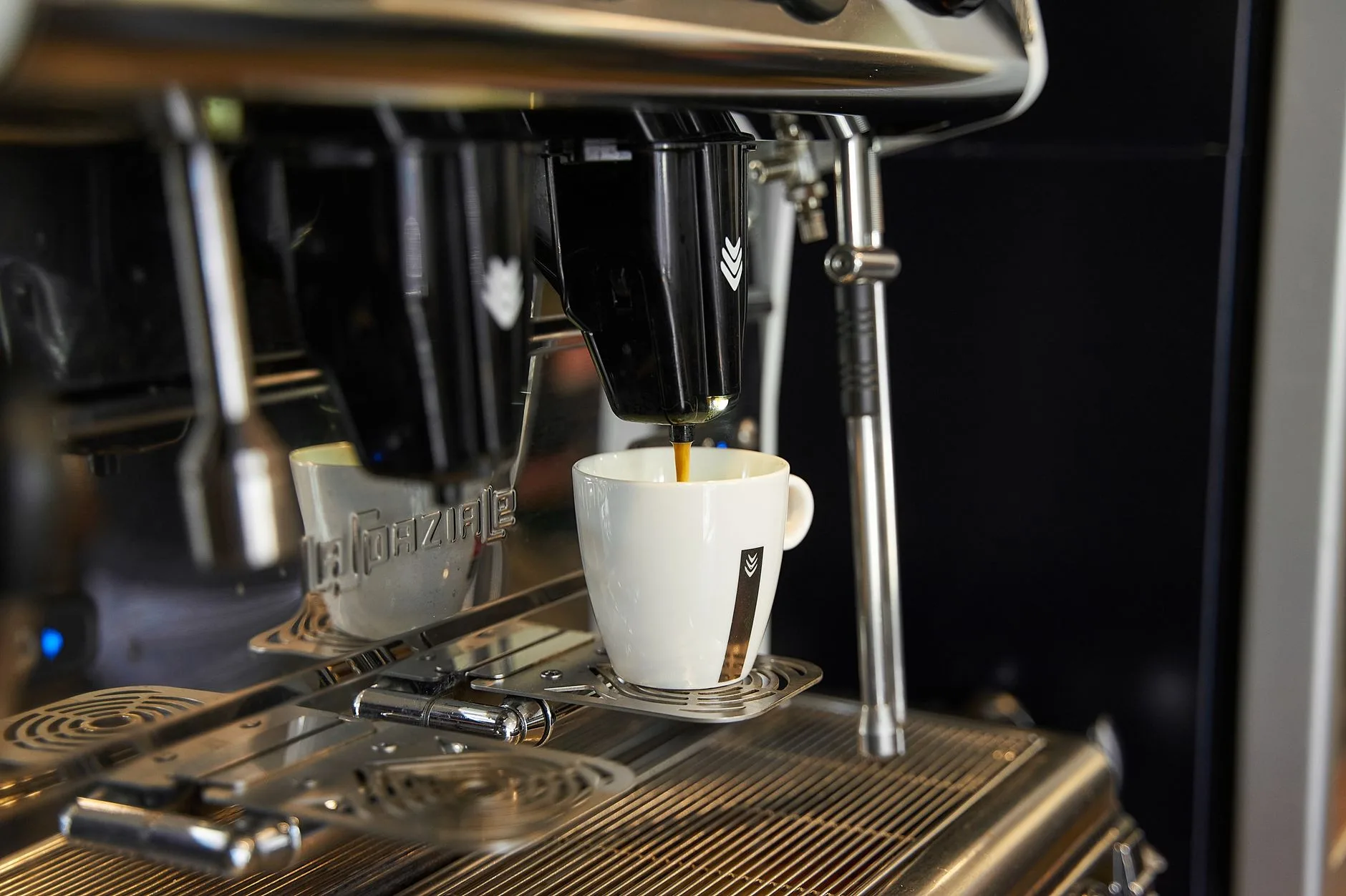 Espresso machine pouring hot coffee into a cup