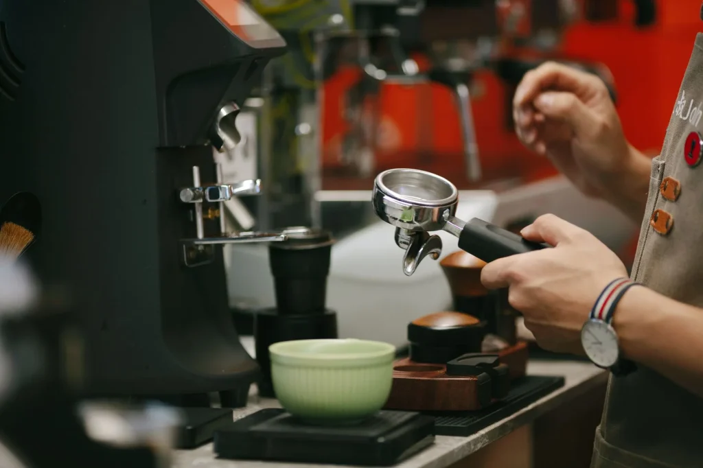 Coffee grinder and espresso portafilter with beans on a kitchen counter