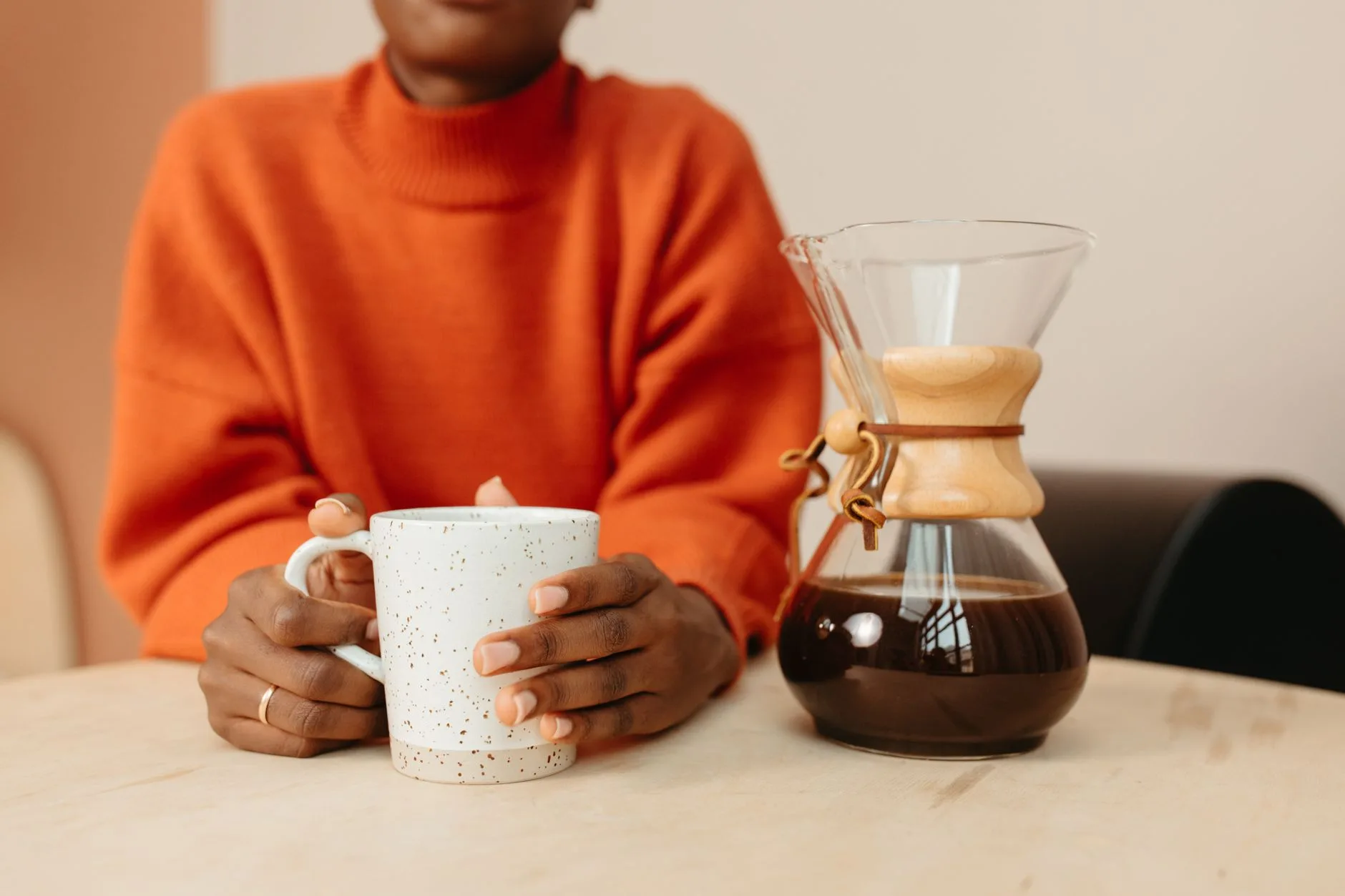 Chemex glass carafe with brewed coffee and mugs on a table