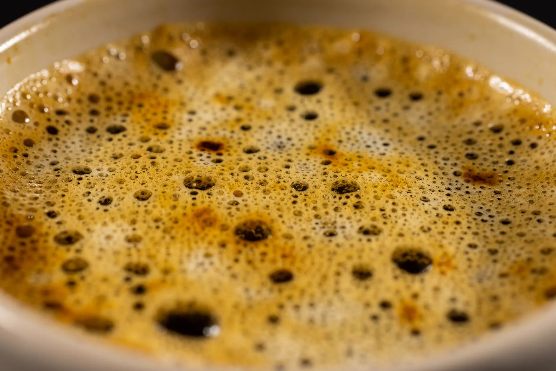 Close-up of a ceramic coffee cup rim showing aroma and shape detail