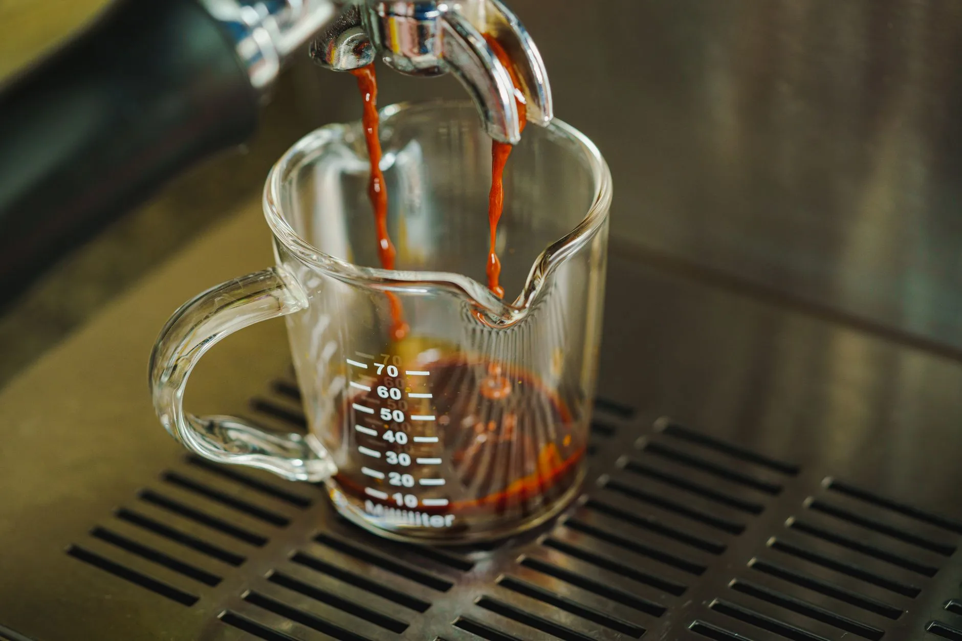 Espresso extracting into a cup after a fine grinder adjustment