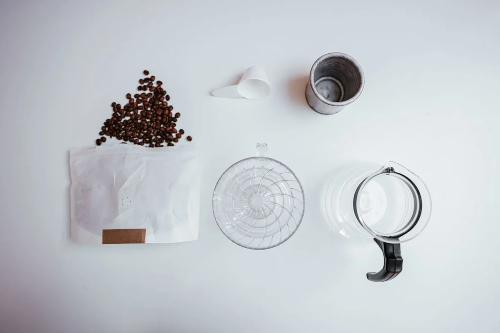 Espresso and filter coffee beans beside a portafilter and dripper