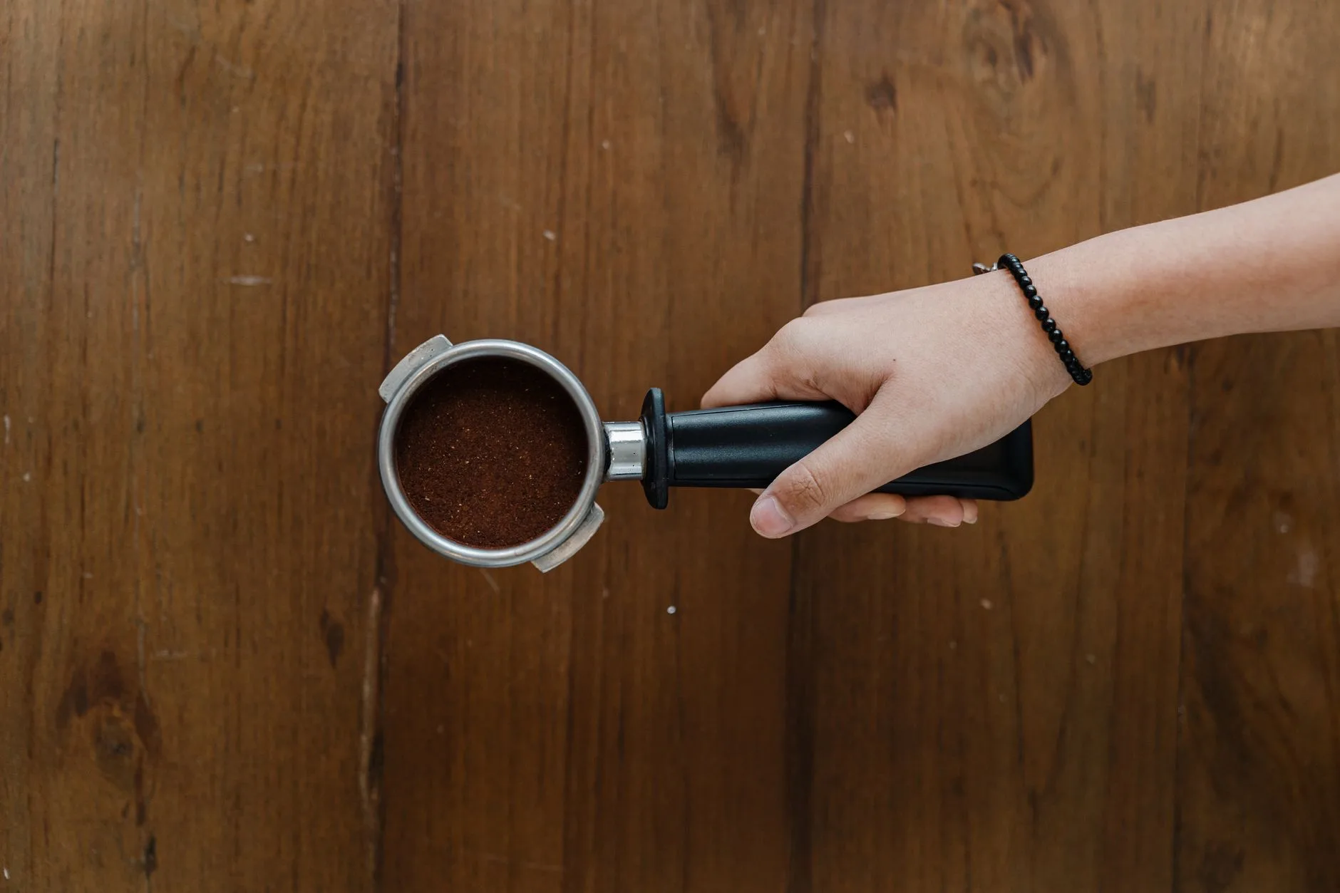 Espresso puck prep with coffee grounds in a portafilter