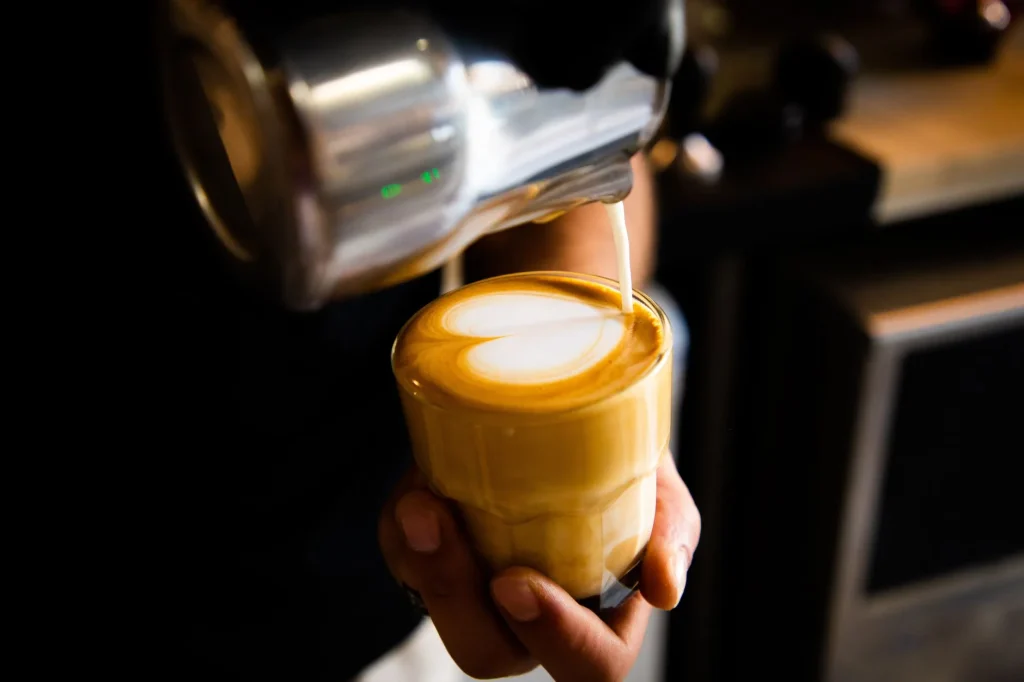 Heart latte art poured into a coffee cup for a beginner guide