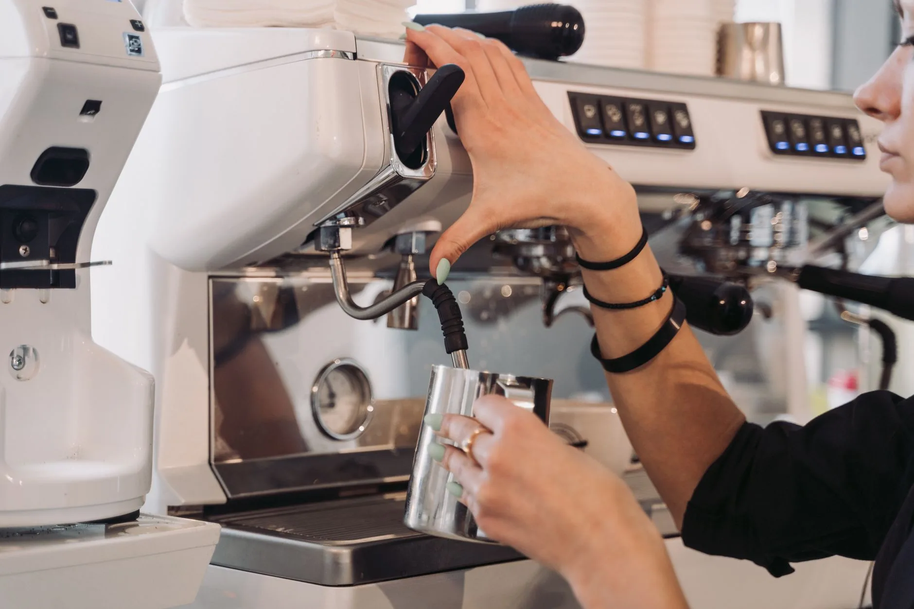 Steam wand texturing milk in a pitcher for latte art